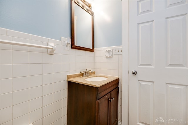 bathroom with a wainscoted wall, tile walls, and vanity