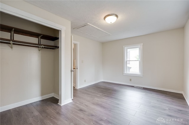 unfurnished bedroom with visible vents, baseboards, dark wood-style flooring, a closet, and a textured ceiling