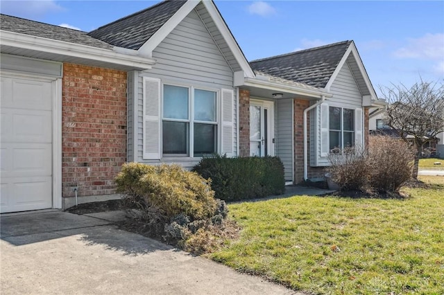 view of front facade featuring brick siding, an attached garage, a shingled roof, and a front lawn