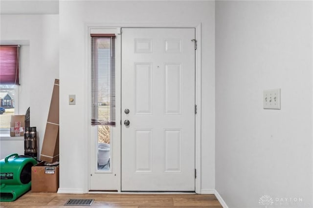 entryway featuring visible vents, baseboards, and wood finished floors