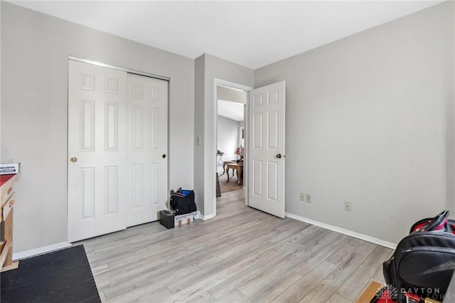 interior space with a closet, baseboards, and light wood-style flooring