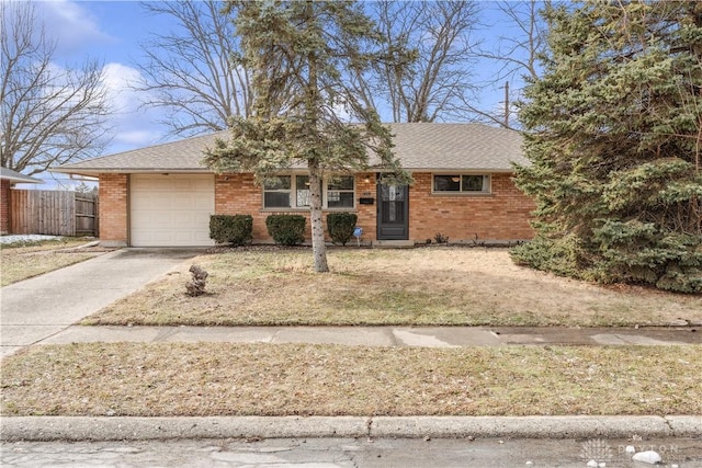 ranch-style home with brick siding, concrete driveway, an attached garage, and fence