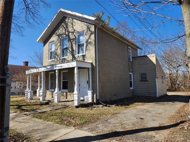 exterior space with brick siding and a porch