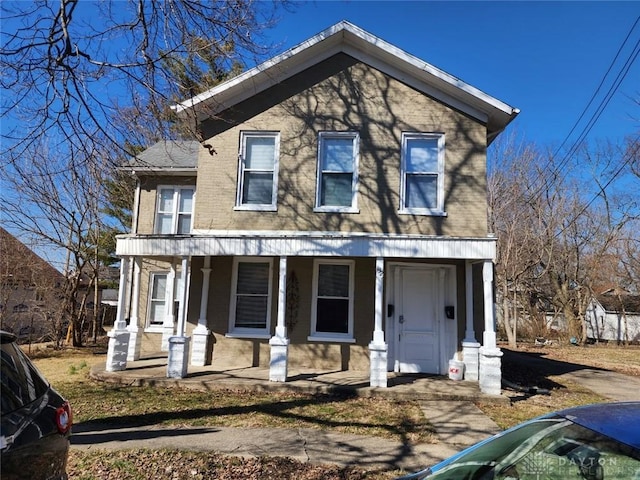 view of front of home with brick siding and covered porch