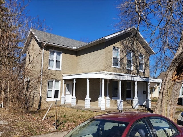 view of front facade with brick siding and a porch