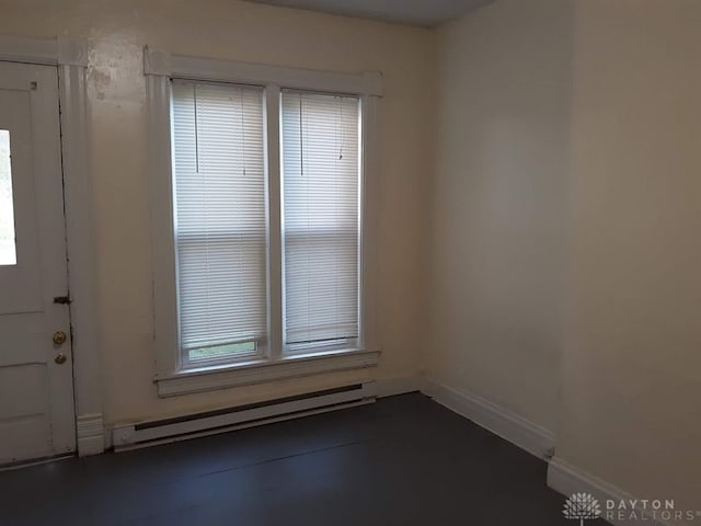 unfurnished room featuring a baseboard radiator and baseboards