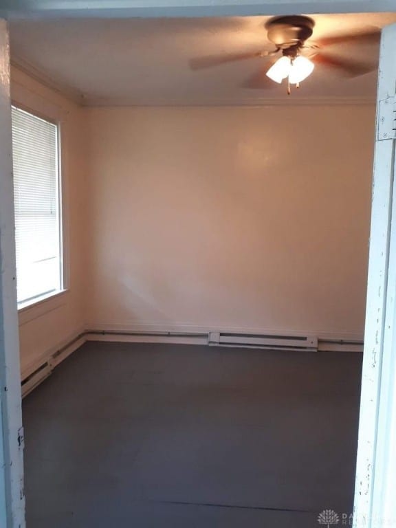 unfurnished room with ceiling fan and crown molding