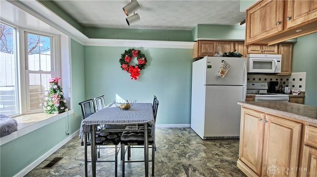 kitchen with white appliances, baseboards, visible vents, and light countertops