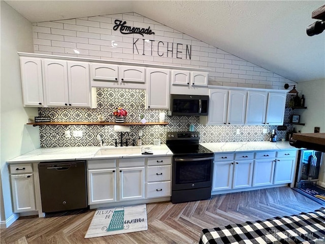 kitchen featuring decorative backsplash, lofted ceiling, black appliances, and white cabinetry