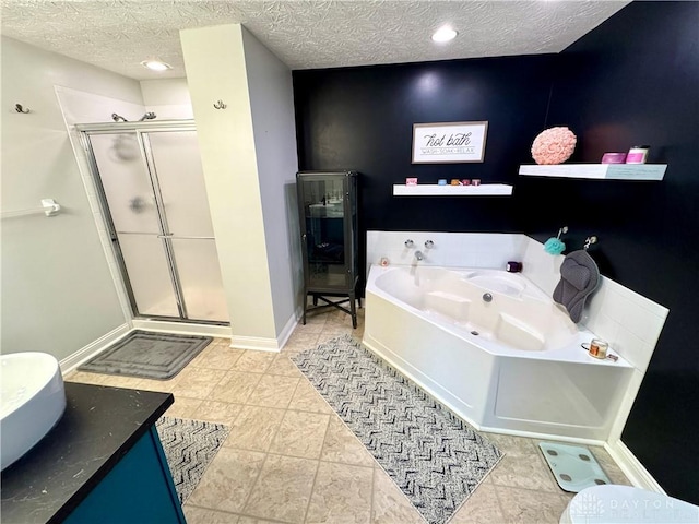 bathroom with a shower stall, a garden tub, baseboards, and a textured ceiling