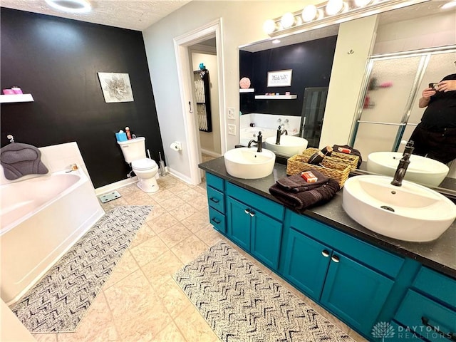 bathroom with double vanity, a stall shower, a sink, a textured ceiling, and a bath