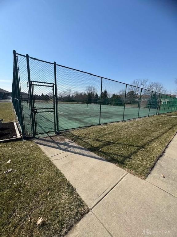 view of tennis court with a gate and fence