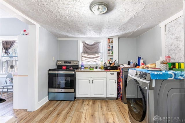 laundry room featuring light wood finished floors, washer / dryer, a textured ceiling, and a sink