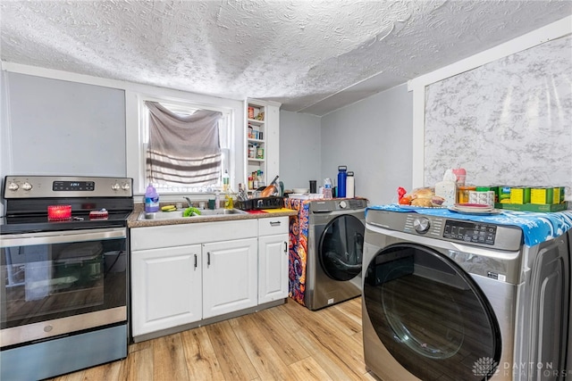 laundry room featuring a sink, light wood-type flooring, a textured ceiling, and laundry area