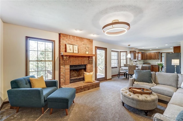 living area featuring baseboards, recessed lighting, a fireplace, a textured ceiling, and light carpet