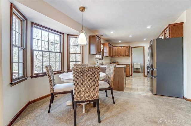 dining room with recessed lighting, light colored carpet, and baseboards