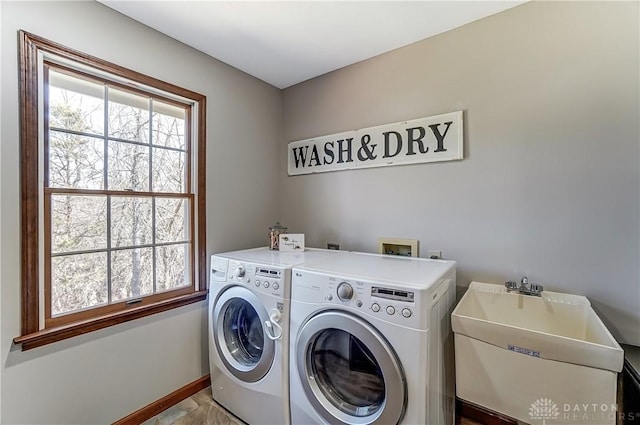 laundry area with washer and clothes dryer, laundry area, baseboards, and a sink