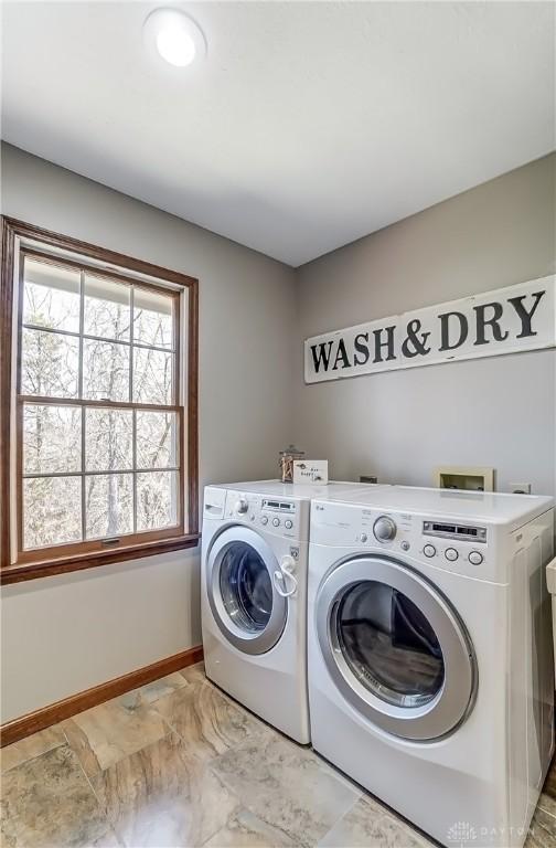 clothes washing area featuring laundry area, separate washer and dryer, baseboards, and marble finish floor