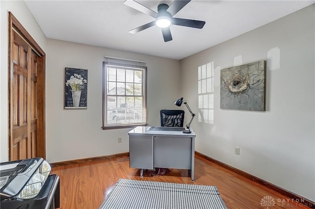 office space featuring wood finished floors, baseboards, and ceiling fan