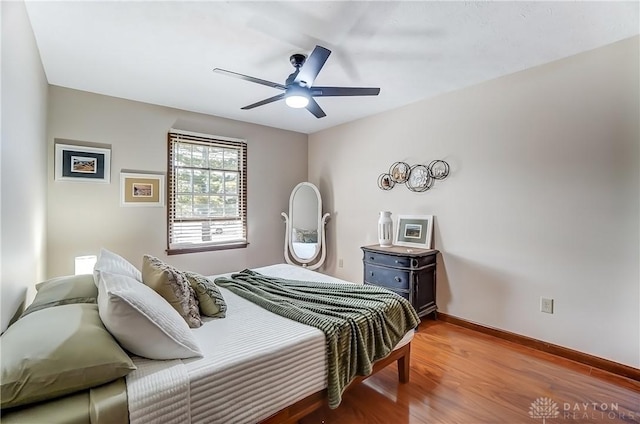 bedroom featuring baseboards, light wood-style floors, and a ceiling fan