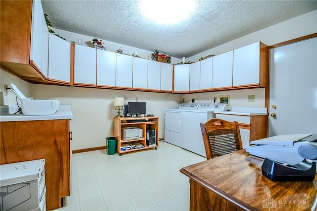 kitchen with a textured ceiling, light floors, baseboards, and washer and clothes dryer