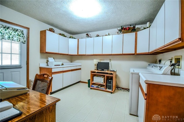 kitchen featuring a textured ceiling, light countertops, light floors, and washer and clothes dryer