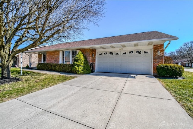 ranch-style home featuring brick siding, an attached garage, driveway, and a front lawn