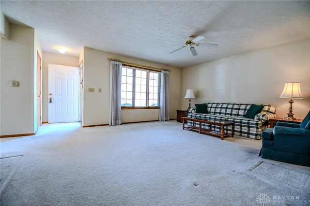 carpeted living area with baseboards, a textured ceiling, and ceiling fan