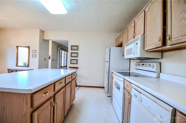 kitchen with a textured ceiling, white appliances, light countertops, and a center island