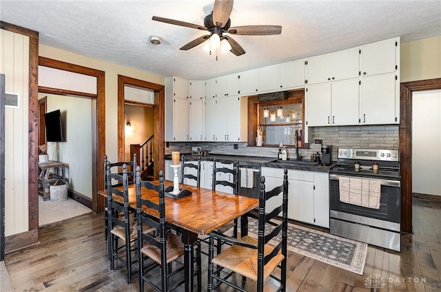 kitchen with electric range, dark wood-style flooring, white cabinetry, and a sink