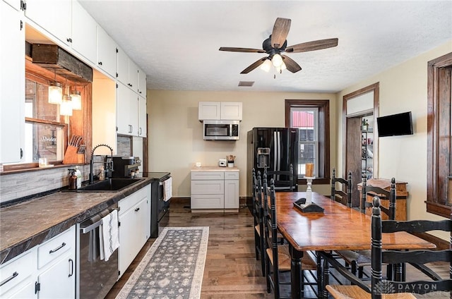 kitchen featuring black appliances, white cabinets, visible vents, and a sink