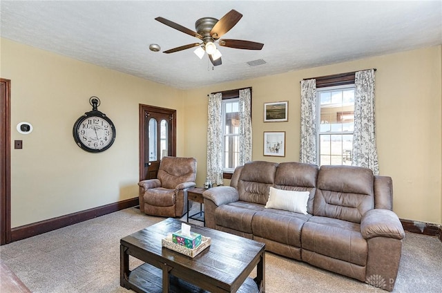 carpeted living area with visible vents, a textured ceiling, a ceiling fan, and baseboards