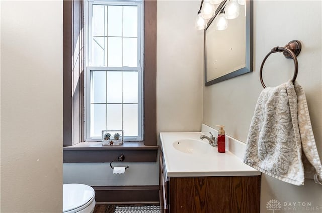 half bathroom with vanity and toilet