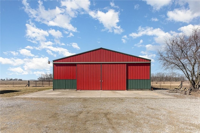 view of pole building with a rural view and fence