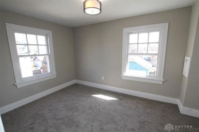 spare room with baseboards and carpet flooring