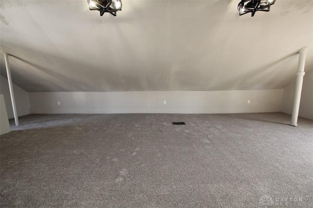 additional living space with vaulted ceiling, carpet, and visible vents