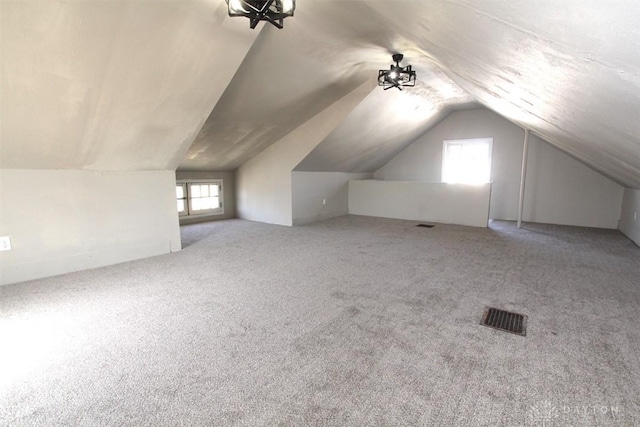 additional living space with vaulted ceiling, visible vents, and carpet floors