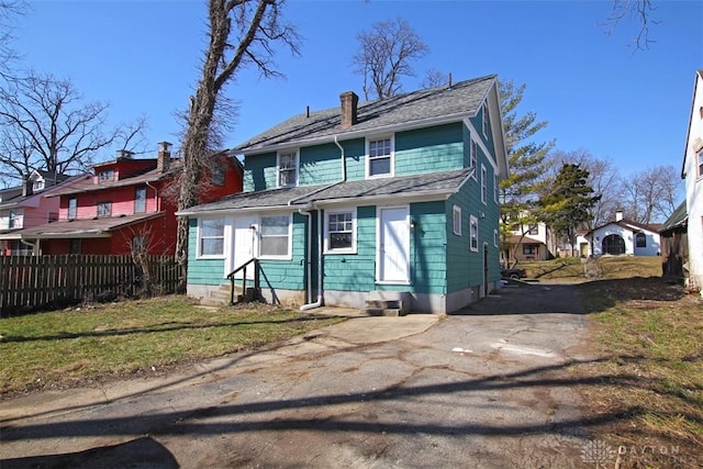 view of front facade with fence, driveway, and entry steps