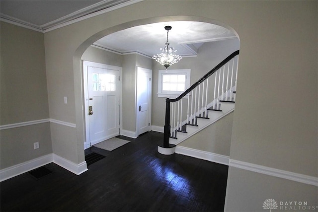 entrance foyer with baseboards, arched walkways, wood finished floors, and crown molding