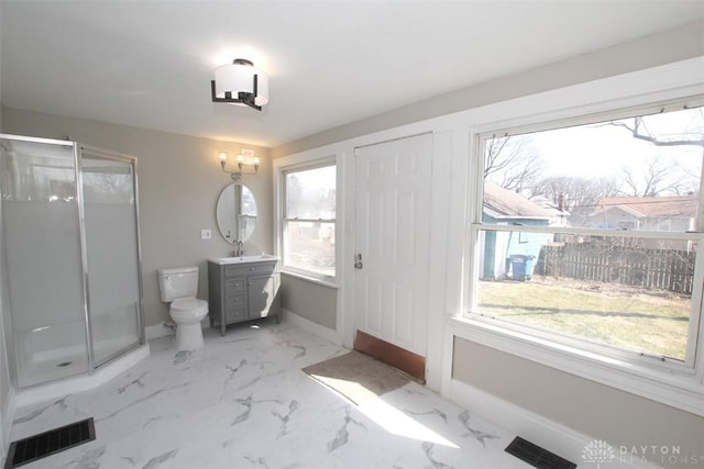 bathroom featuring vanity, a shower stall, toilet, and visible vents