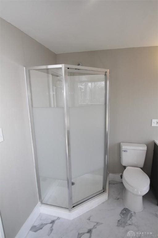 bathroom with vanity, baseboards, a shower stall, toilet, and marble finish floor