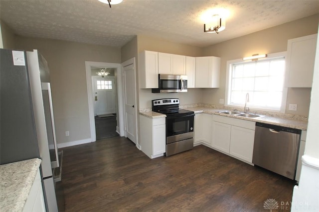 kitchen featuring dark wood-type flooring, plenty of natural light, appliances with stainless steel finishes, and a sink