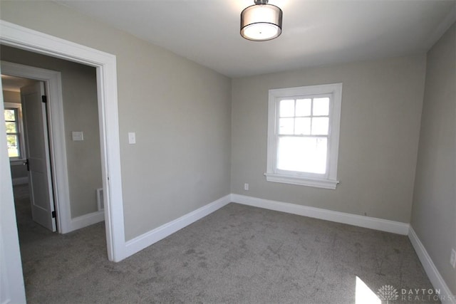 carpeted empty room with baseboards