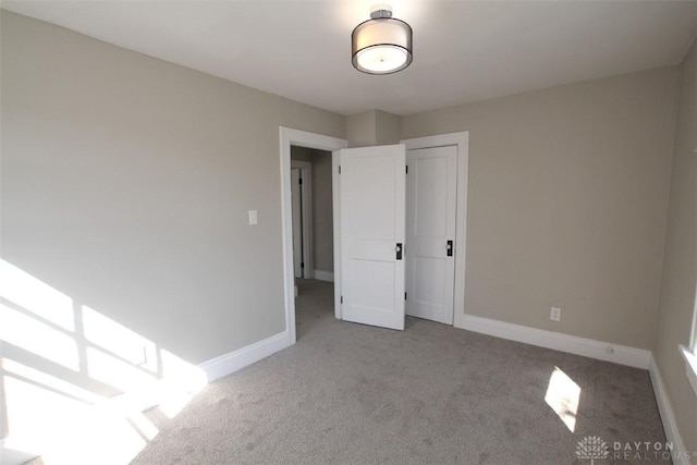 unfurnished bedroom with baseboards and carpet floors