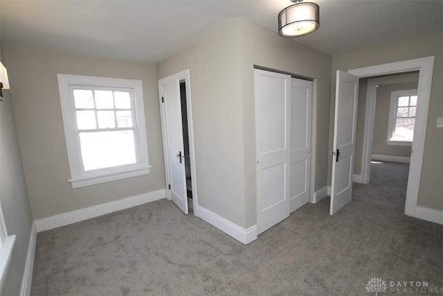 unfurnished bedroom featuring carpet, a closet, and baseboards