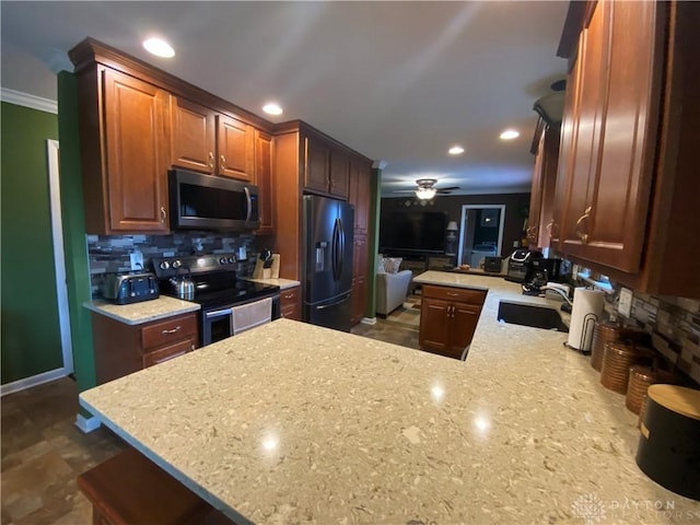 kitchen featuring a peninsula, electric range, a sink, stainless steel microwave, and black refrigerator with ice dispenser