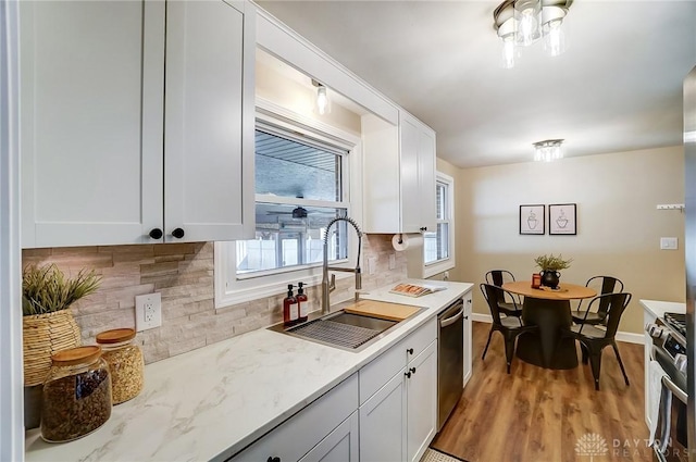 kitchen featuring white cabinets, plenty of natural light, appliances with stainless steel finishes, and a sink