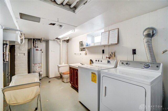 washroom featuring gas water heater, cabinet space, and washer and clothes dryer