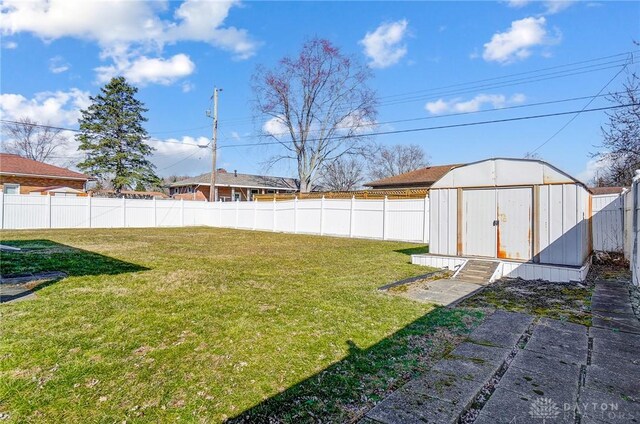 view of yard featuring a storage unit, a fenced backyard, and an outdoor structure