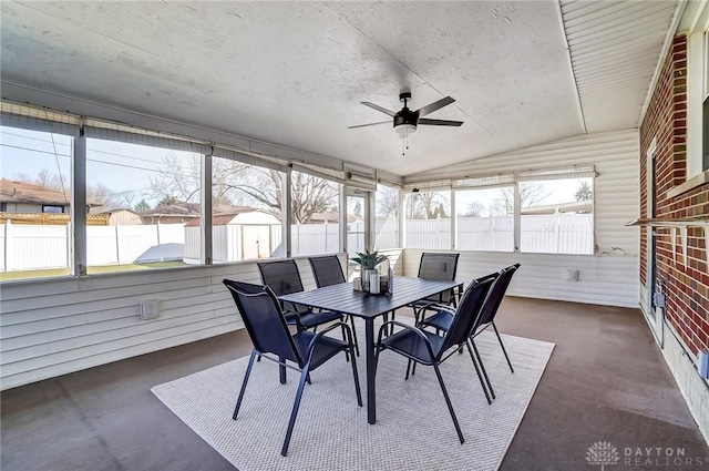 sunroom / solarium with a ceiling fan and vaulted ceiling